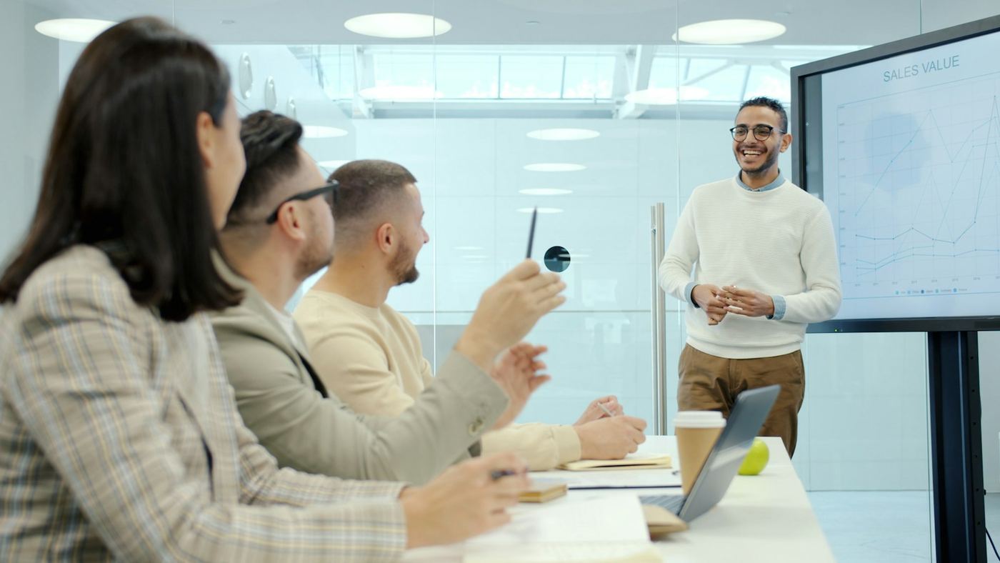 Un formateur présente devant un groupe dans une salle moderne